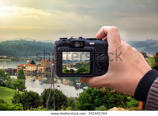 hand holding the Digital camera, shoot of\
landscape photo using\
liveview