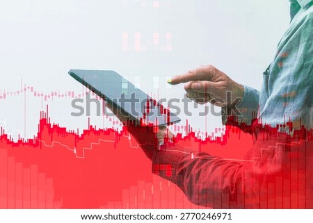 Hand holding a digital tablet and analyzing stock market downfall. Red candlestick graph data visualization is overlaid for financial loss, crisis, or bearish trend. Concept for business analysis