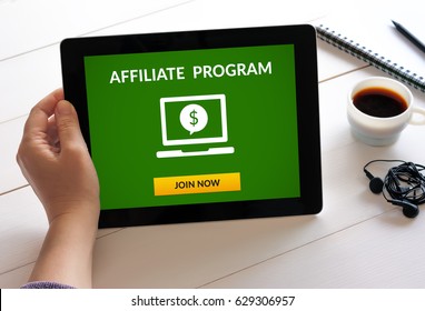 Hand holding digital tablet computer with affiliate program concept on screen. All screen content is designed by me