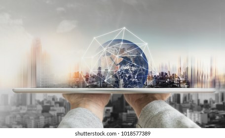 Hand holding digital tablet with global network connection technology and modern buildings. Element of this image are furnished by NASA