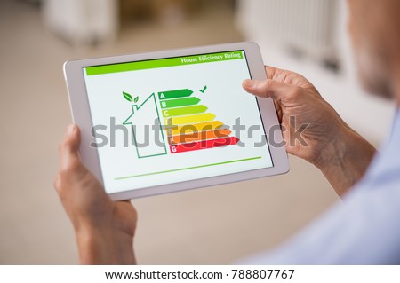 Hand holding digital tablet and looking at house efficiency rating. Detail of house efficiency rating on digital tablet screen. Concept of ecological and bio energetic house. Energy class.