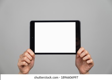 Hand Holding Digital Tablet On Gray Background.