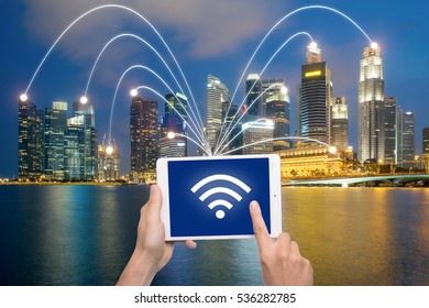 Hand Holding Digital Tablet And Singapore City With Network Connection. Smart City Network Connection Concept.