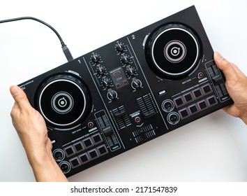 Hand holding a DJ controller Deck set isolated on white background. - Shutterstock ID 2171547839