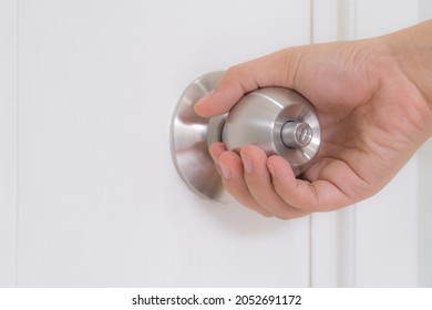 Hand Holding Door Knob On White Door. Opening Door Knob. Copy Space For Text.