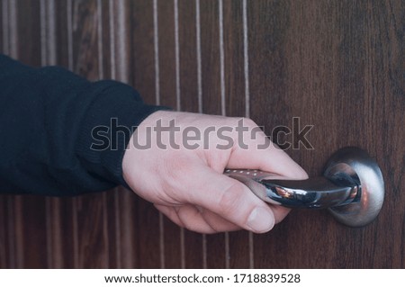 The hand is holding the doorknob. Opens the door.