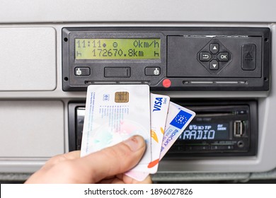 Hand Holding A Driver Digital Card, Bank Debit Card And And Europian Driving Licence Infront Of A Digital Tachograph. No Personal Data.