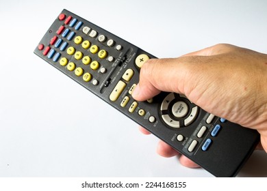 Hand holding a dusty audio video receiver remote control