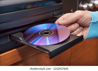 Hand holding DVD inserting to video player