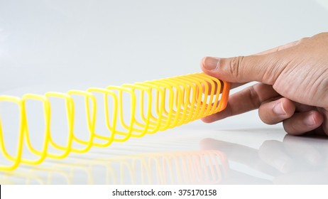 Hand Holding Elastic Spring Coil On Empty Background. Concept Of Business Flexibility. Slightly De-focused And Close-up Shot. Copy Space.