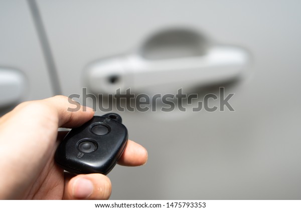 hand holding\
a electronic car key, white car\
door