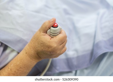 A hand holding emergency button in hospital room. Emergency button for hospital patients.