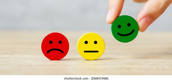hand holding emotion face block. Customer choose Emoticon for user reviews. Service rating, ranking, customer review, satisfaction, mood, evaluation and feedback concept - Shutterstock ID 2068419686