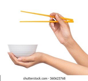 Hand holding an empty bowl and chopsticks isolated on white background