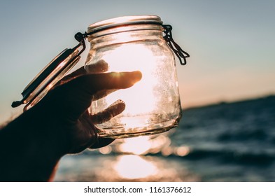 Hand Holding Empty Jar In The Sunlight