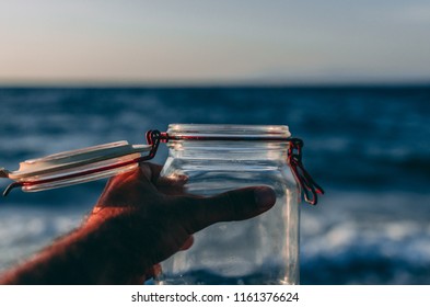 Hand Holding Empty Jar In The Sunlight