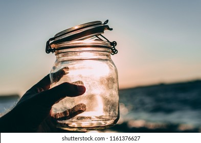 Hand Holding Empty Jar In The Sunlight