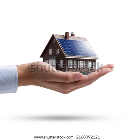 Hand holding an energy efficient model house with solar panels, ecology and sustainability concept On white backgroundbackground