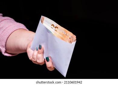 Hand Holding Euro Banknotes In The Envelope Isolated On Black Background, Corruption, Bribe, Closeup