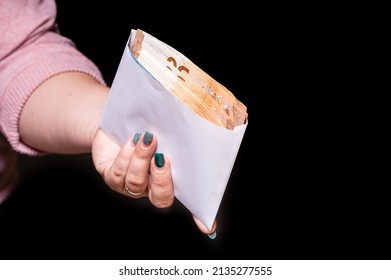 Hand Holding Euro Banknotes In The Envelope Isolated On Black Background, Corruption, Bribe, Closeup