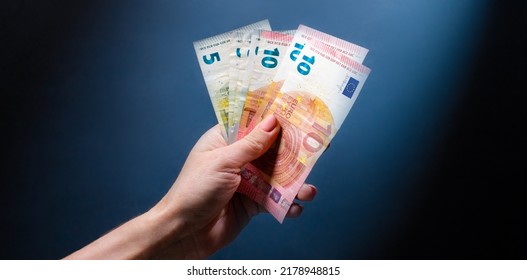 Hand holding euro banknotes. European currency in cash and person with money - Shutterstock ID 2178948815