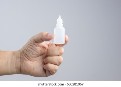 Hand Holding Eye Or Ear Drop Bottle On White Background