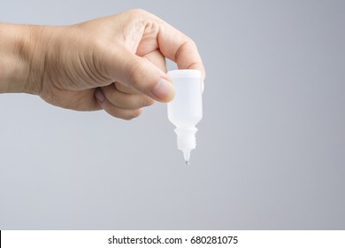 Hand Holding Eye Or Ear Drop Bottle On White Background