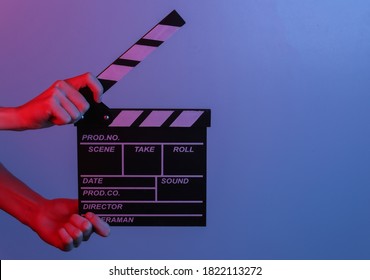 Hand Holding Film Clapper Board In Blue Red Neon Light. Cinema Industry, Entertainment.