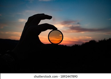 Hand Holding filter lens camera, sunset, mountain, landscape