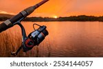 Hand holding fishing rod and reel, sunset fishing at Ross lake at Galway, Ireland, spinning, angling, catch and release, sport and leisure, nature background	