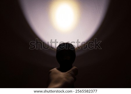 A hand holding a flashlight in the dark