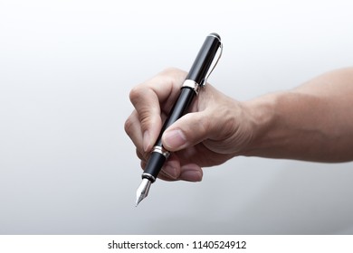 
A hand holding a fountain pen