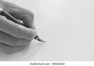  hand holding fountain pen write on white paper - Shutterstock ID 783344263