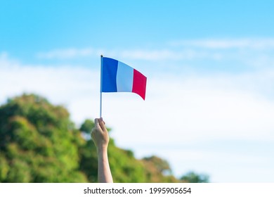 hand holding France flag on blue sky background. holiday of French National Day, Bastille Day and happy celebration concepts - Powered by Shutterstock