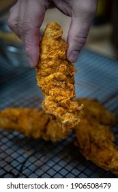 Hand Holding Fried Chicken Tender