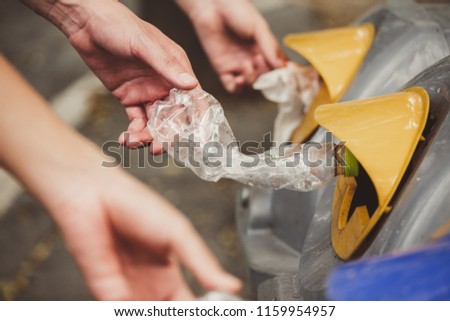 Hand holding garbage bottle plastic putting in recycle bin
