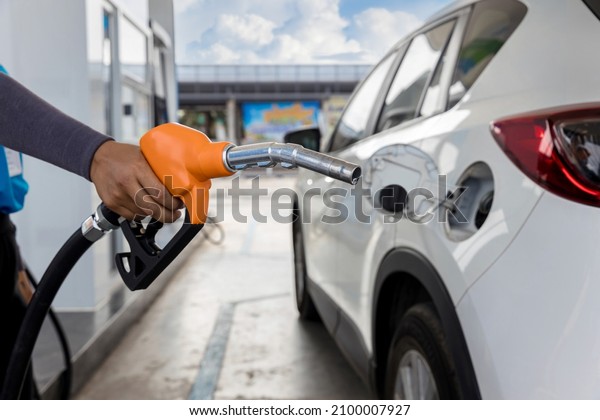 Hand holding gas nozzle with one last drop.\
A man holding a gasoline nozzle . Hands of men who were holding an\
automatic nozzle to make refill oil.\
