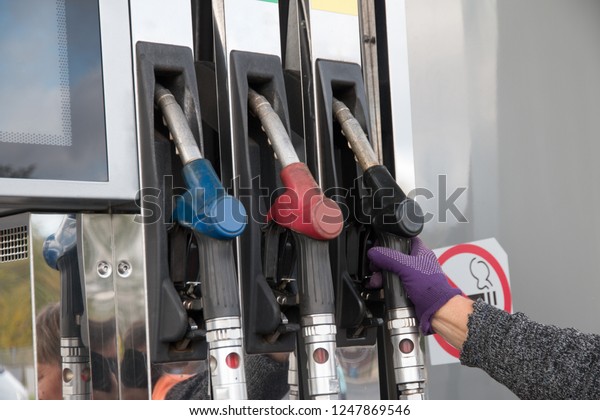 Hand holding a\
gasoline gun at a gas\
station