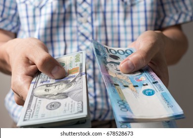 Hand holding giving cash banknote of one thousand Philippines peso and US dollars. Money exchange