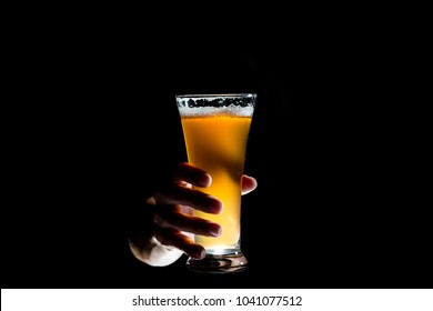 Hand Holding Glass Of Craft Beer On Black Background