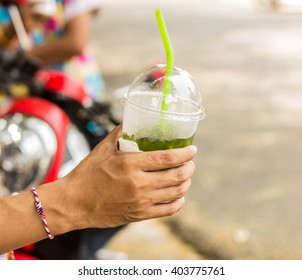 Hand holding a glass of green tea - Shutterstock ID 403775761