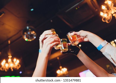 Hand holding a glass shot with vodka shot.