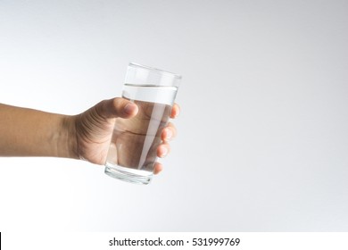 Hand Holding A Glass Of Water On White Background