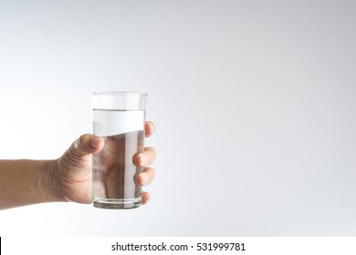 Hand Holding A Glass Of Water On White Background