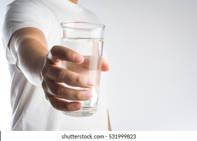 Hand holding a glass of water on white background