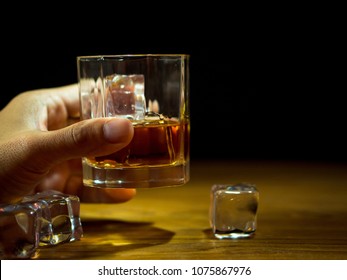 Hand Holding The Glass Of Whiskey, On The Rock Of Whiskey