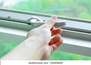 Hand Holding Glass Window Latch Handle