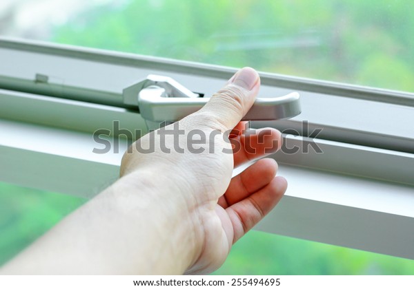 Hand holding glass\
window latch handle