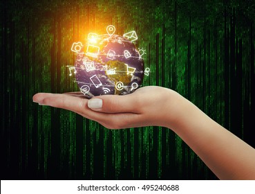 hand holding globe and media icons flying in front of matrix binary code background