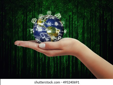 hand holding globe and media icons flying in front of matrix binary code background